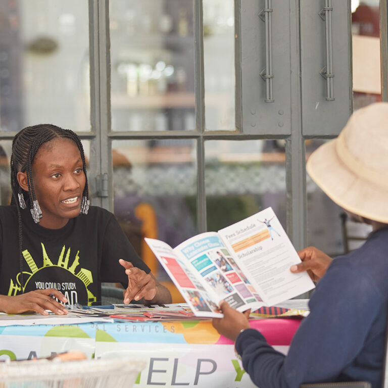 Punzila counsellor showing a university brochure to a visitor