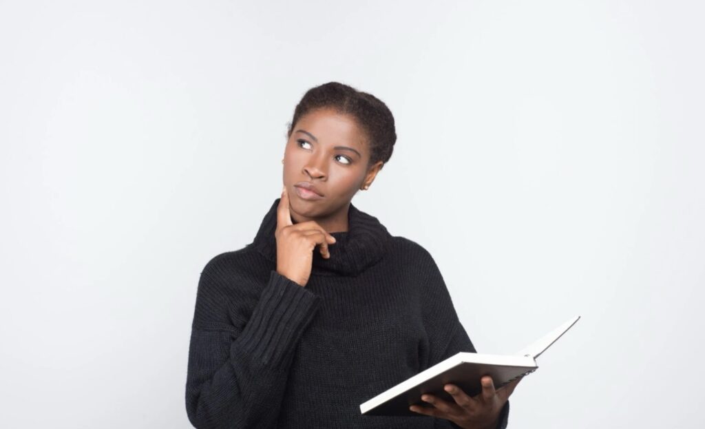 Student thinking carefully while holding an open notebook